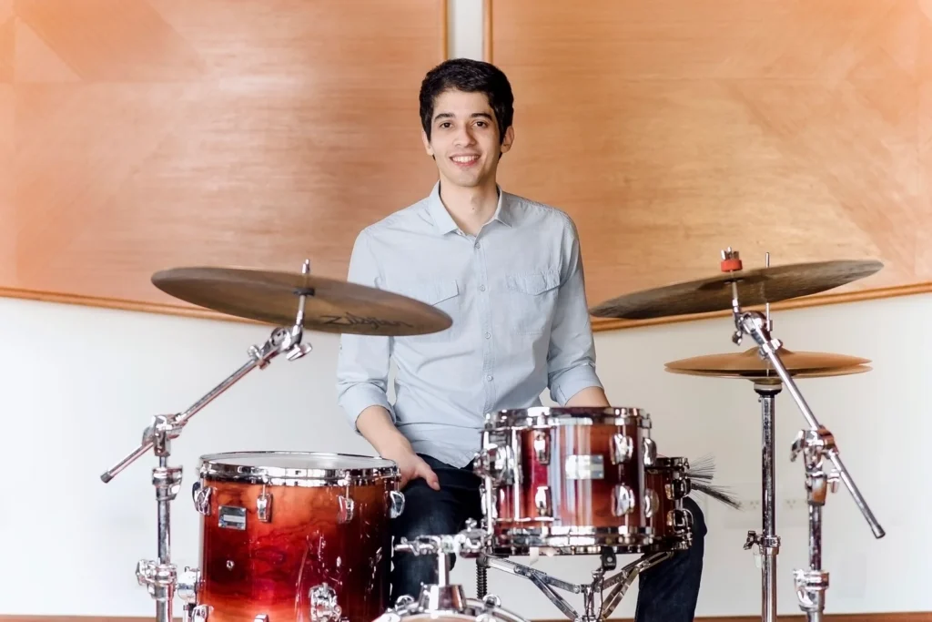 Professor Zeca Vieira sentado à bateria em estúdio profissional preparado para aula de bateria Valinhos SP presencial.