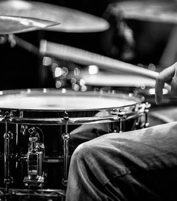 Close-up das mãos do professor Zeca Vieira tocando a caixa e os pratos durante as aulas de bateria em Valinhos em seu estúdio profissional.